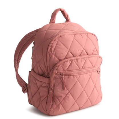Pink quilted backpack on a white background